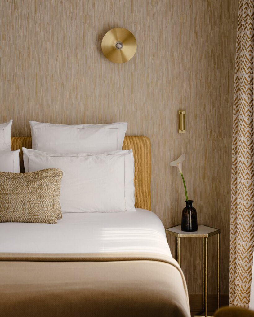 Détail d’un plaid en maille beige sur lit, texture textile haut de gamme